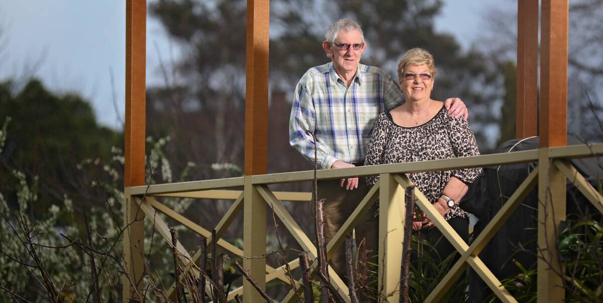 NEW LIFESTYLE: Tom and Jenni Rush stand on their decking and enjoy the view of Launceston from their cottage at Cosgrove. Picture: Phillip Biggs
