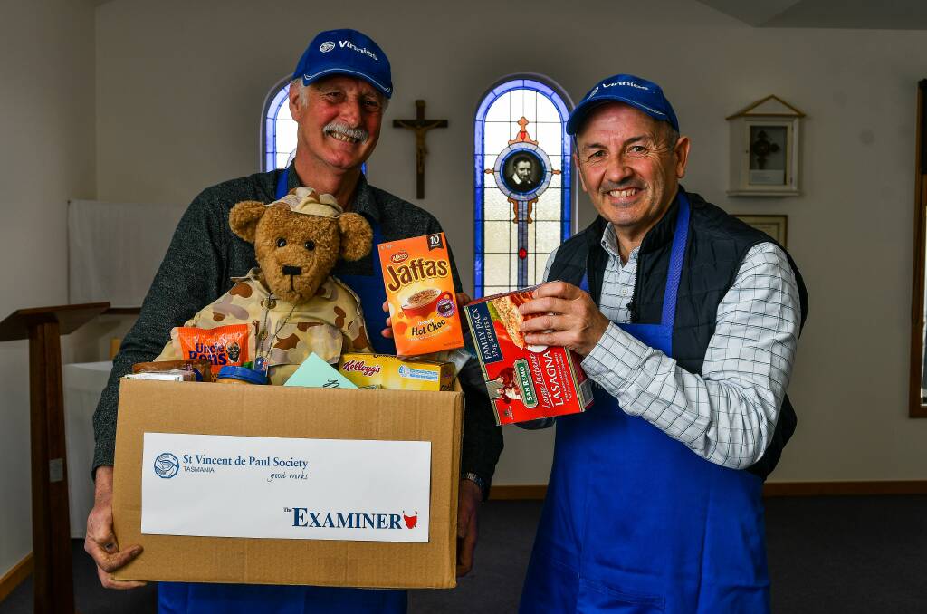 GENEROSITY: St Vincent de Paul's Vyv Allchin and Mark Gaetani with one of the many Christmas hampers the society will distribute this year. Picture: Scott Gelston