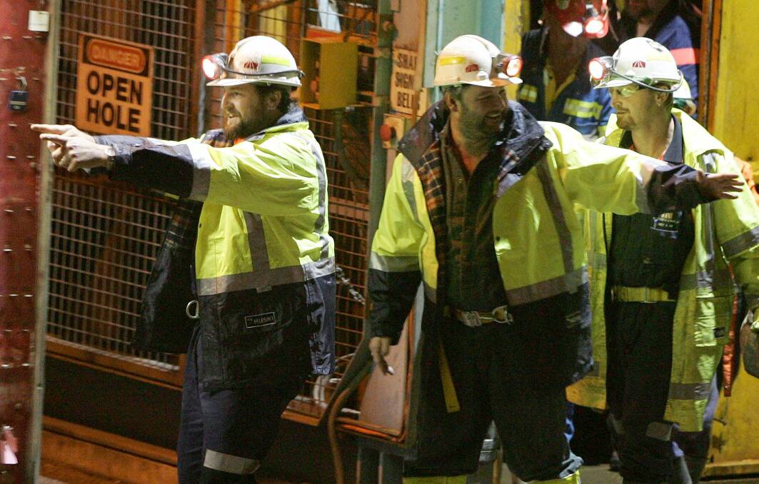 Miners Todd Russell, left, and Brant Webb, center, take their first steps above ground after spending two weeks trapped when the Beaconsfield mine collapsed. Picture: AP
