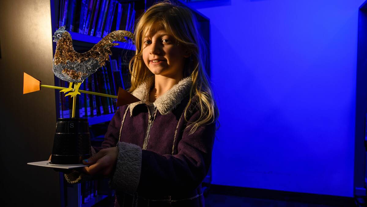 WEATHER LEARNING: Violet Hammond, 7, with a weather vane that was made at the Launceston Library's school holiday program. Pictures: Scott Gelston