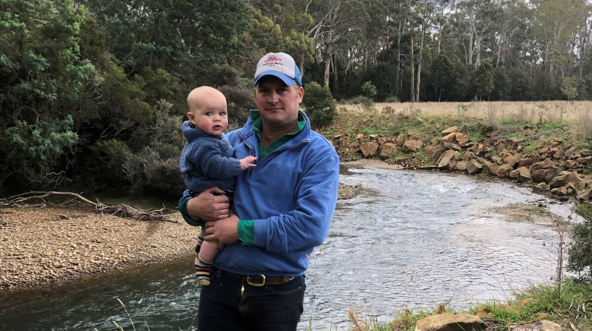 RECIPIENT: Tasmanian farmer Ben Morrison and his son Bruce, eight months, at the site of the river where they have conducted work through grants from Tamar NRM. Picture: supplied