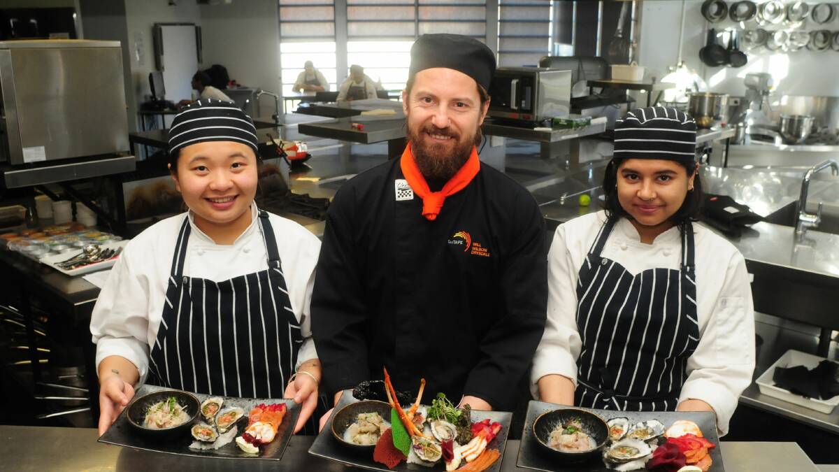 COME AND LEARN: Drysdale cookery teacher Will Wilson with Shayne Wei and Nur Hamid, preparing for the TasTAFE info week session. Picture: Neil Richardson