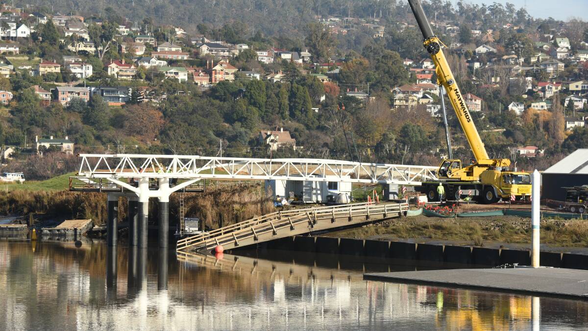 SEAPORT LINK: The pedestrian bridge connecting the Seaport with North Bank has begun to be constructed in Launceston. The first link was put in place on Tuesday. Picture: Paul Scambler