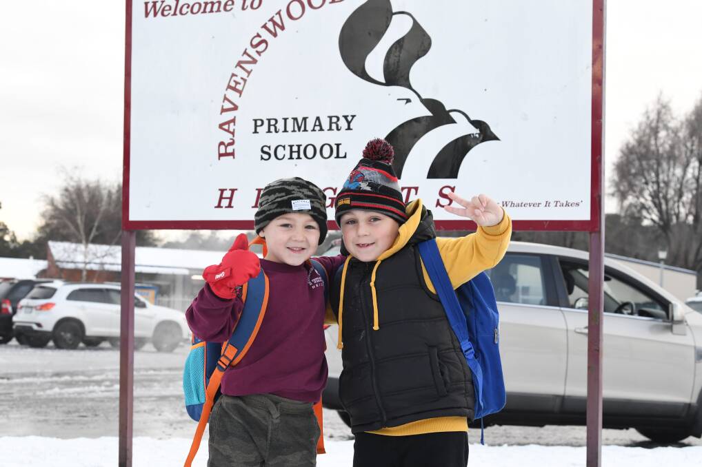 SNOW DAY: Carsen Young, 6, and brother Cohen, 8, heading to Ravenswood Primary School in the snow. Picture: Neil Richardson 