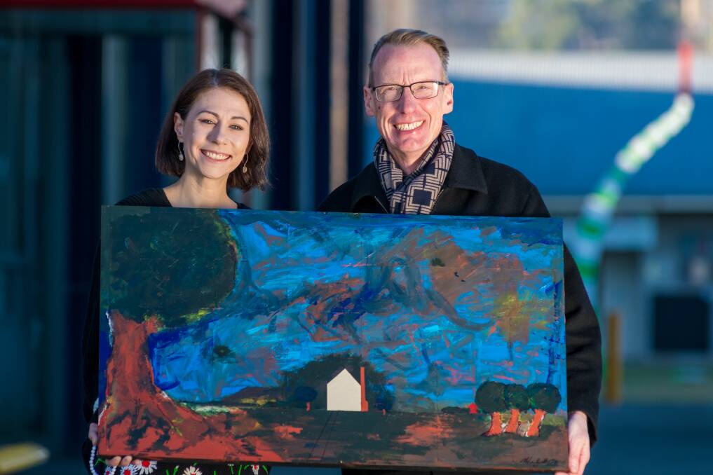 SUPPORT: Exhibition curator Anna Van Stralen and Academy Gallery director Malcom Bywaters with a painting that will be auctioned, proceeds to Winter Relief. Picture: Phillip Biggs