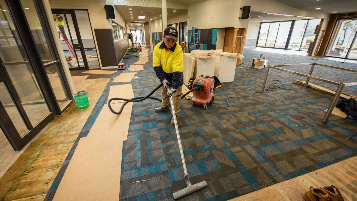 Aden Hoggett, of Premium Constructions, cleans up Queechy High School's new C block ahead of students' arrival on Tuesday. 