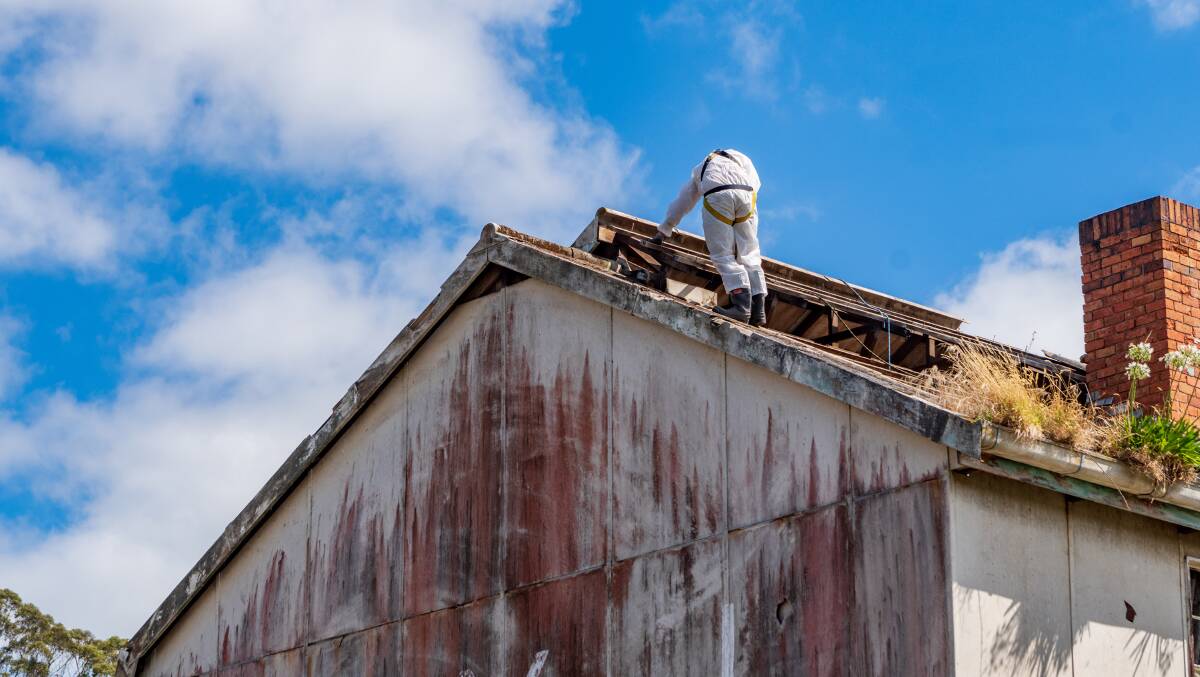 AT WORK: Contractors from Mendelssohn Construction work to secure the roof of the old IXL building as part of asbestos removal. Plans are underway to demolish the building to make way for a subdivision. Picture: Phillip Biggs