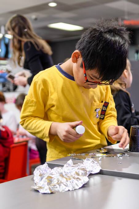 Zachary Goh, 8, works on his weather vane to add copper leaf to the design.