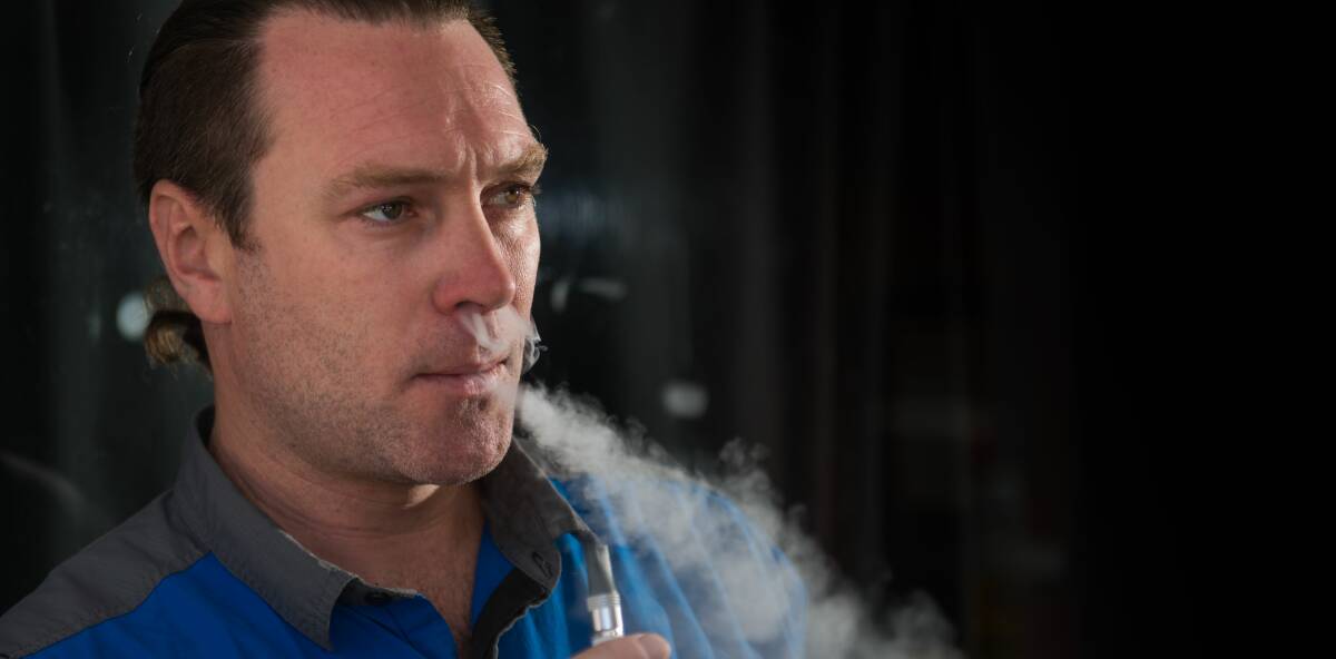 SMOKE: Vape Trail retail manager Ben Vigers with an e-cigarette. Picture: PHILLIP BIGGS