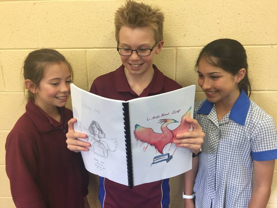 NOW PUBLISHED: Riverside Primary School grade 5 pupils Alice Daveney, Aiden Thurm and Isha Dave look at The Write Road anthology. Picture: Johanna Baker-Dowdell