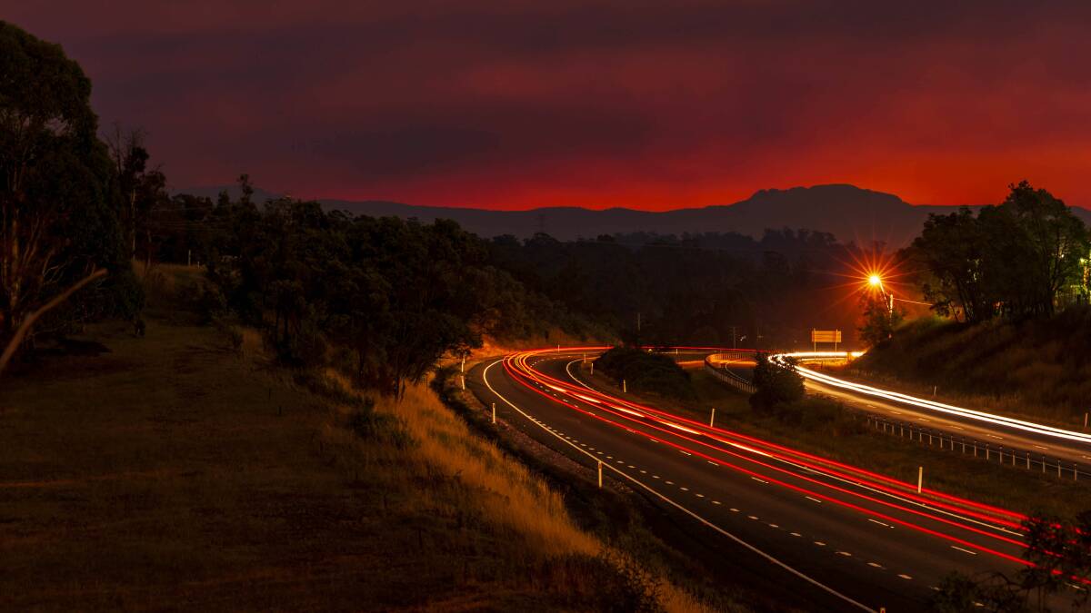 RED SKY: Smoky sunset from a bushfire in the central highlands, photographed from the Bass Highway overpass at Prospect. Picture: Phillip Biggs