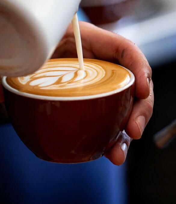 Jack McNiff pours milk into the coffee to create art for his customer. Picture: Supplied