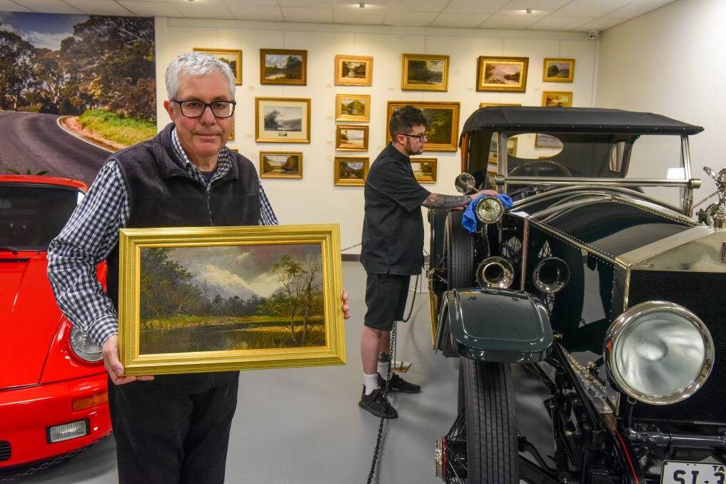 Curator Martin McBean showing one of the paintings alongside the Rolls-Royce. Picture: Paul Scambler The Examiner.