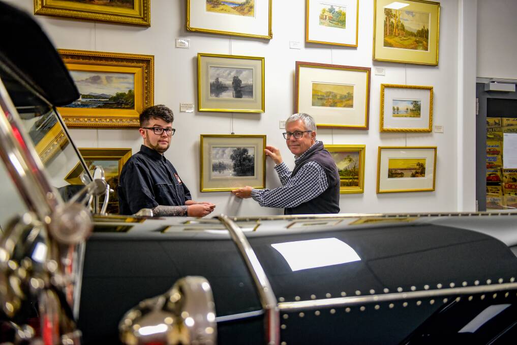 Art attack: National Automobile Museum's Dylan Costello and curator Martin McBain with the paintings by Gladstone Eyre. Picture: Paul Scambler The Examiner.