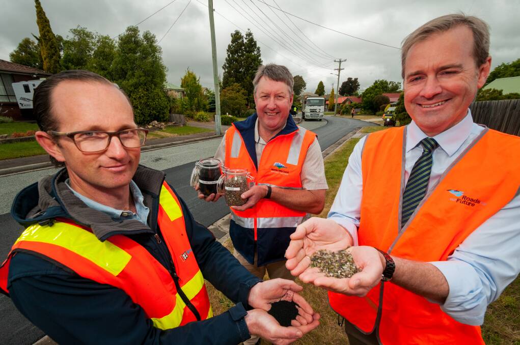 Fulton Hogan state manager Sam Allen, Meander Valley mayor Wayne Johnston, and Infrastructure Minister Michael Ferguson exhibit what goes into a recycled resurfacing of a road. Picture: Phillip Biggs