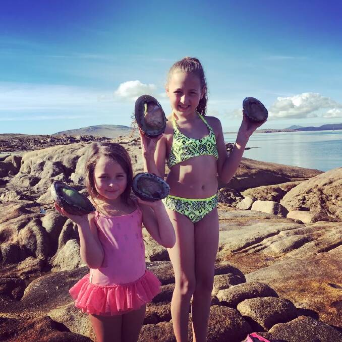 GENERATIONAL PRACTICE: Aaron Everett's daughters Molly and Jolie with some abalone caught off Big Dog island during mutton bird season. Picture: Supplied
