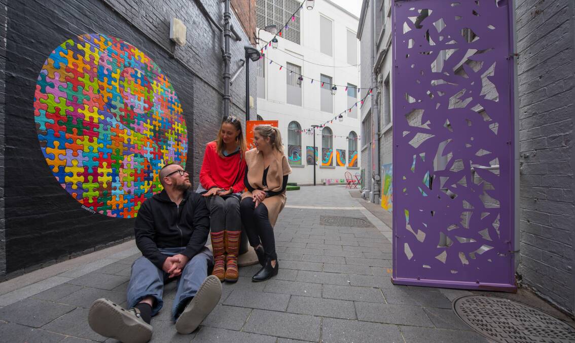 COLOURFUL: Street art is unveiled at Dicky White’s Lane by artists Fakington Wilde and Justine Kelly along with Cityprom marketing assistant Larissa Murray. Picture: Scott Gelston. 