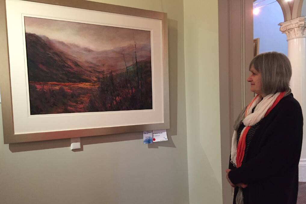 PICTURE PERFECT: Artist Rachel Howell admires her 2016 Tasmanian Art Award winning piece 'Hills of Queenstown' on display at Eskleigh. This year was the sixth time she has entered the exhibition. Picture: Tarlia Jordan 