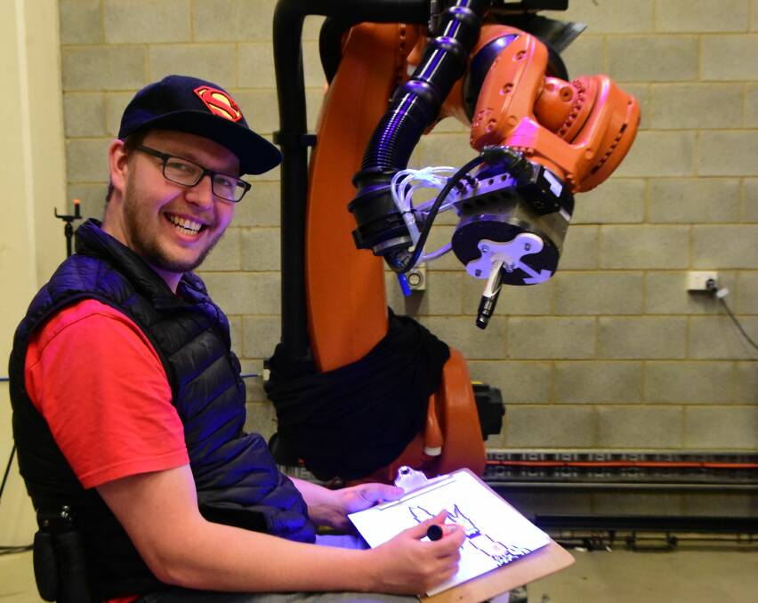 Ben Winwood of Launceston teaches Kuka Bob the Robot to draw a tree as part of his role in  MechanOptera. 