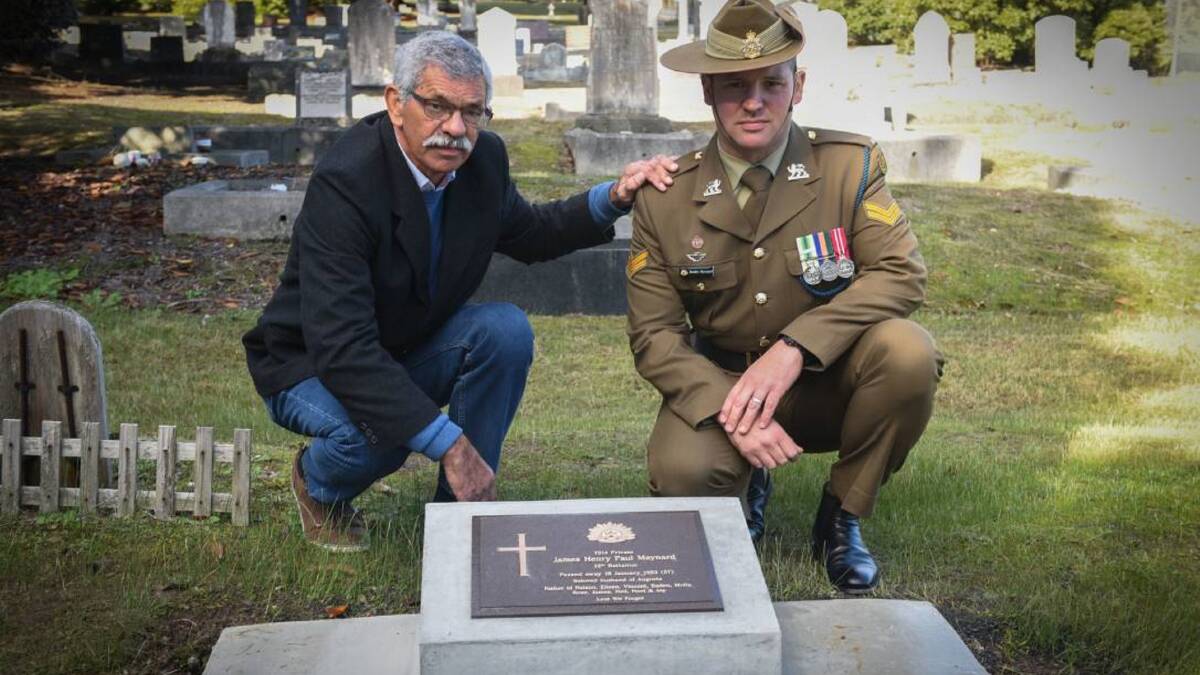 FAMILY TRADITION: Neil Maynard and his son Corporal Bradley Maynard look at the new headstone for Neil's grandfather James Henry Paul Maynard. Picture: File/Paul Scambler