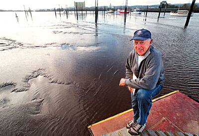 HIGH AND DRY: Silt Action Group member John O'May stands on the Tamar Rowing Club pontoon, which is stranded on the mud at low tide. Boat owners have abandoned the mooring posts in recent years as sil