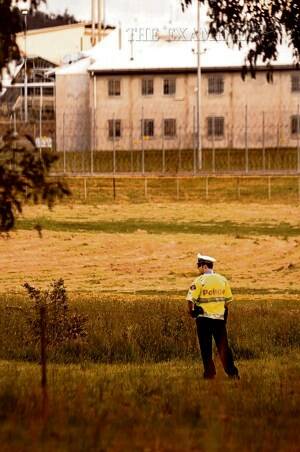 A police officer patrols at Risdon Prison yesterday. Picture: JASON MOREY