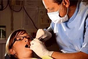 Dr Wayne Ottaway inspects Jessica's Totham's teeth. Picture: PHILLIP BIGGS