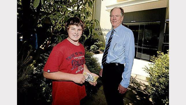 Ashley Bowerman, 14, makes a cash donation to Holman Clinic manager Grant Smith. Picture: GEOFF ROBSON
