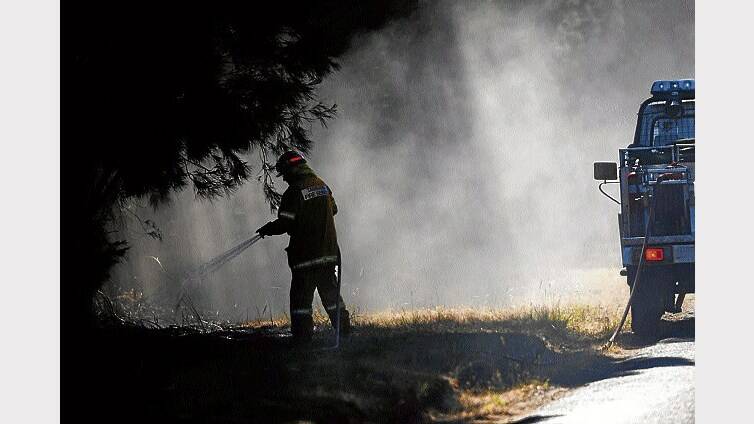 TFS crews mop up along Sandy Point Road, Bridport, after Sunday night's watch and act level fire.  Picture: SCOTT GELSTON