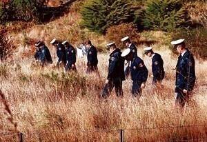 Police scour the area near Seascape Cottage where Martin Bryant was finally apprehended.