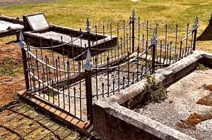 A grave with a spiked wrought-iron fence, earmarked for removal.