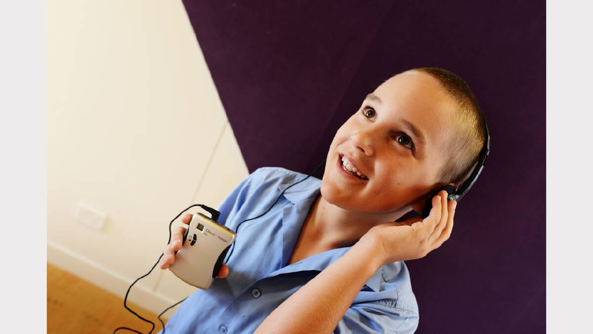 Eight-year-old Bradley Nicholas tries out his new hearing device thanks to the George Town Lions Club. Picture: SCOTT GELSTON
