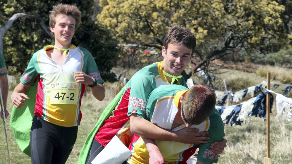 Tasmania's  Shaun McDonough embraces  teammate Brodie Nankervis, with senior orienteering teammate Jade Kerber looking on, after the trio helped Tasmania secure back-to-back national titles yesterday. Picture: ALEX DRUCE