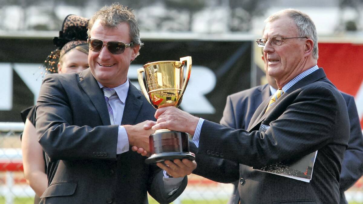  Winning trainer Darren Weir  receives the Hobart Cup from Governor Peter Underwood yesterday.
