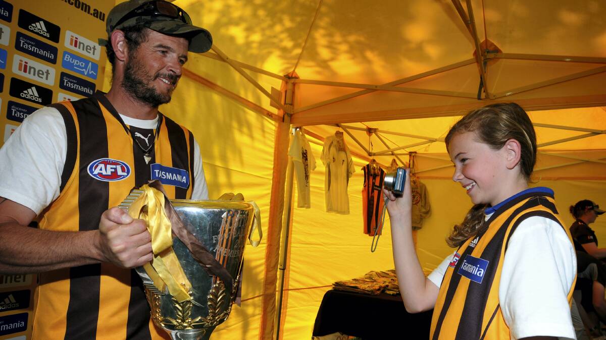 Neil Street, of West Launceston, has his photo taken with the AFL Premiership Cup  by daughter, Olivia Street. Picture: GEOFF ROBSON