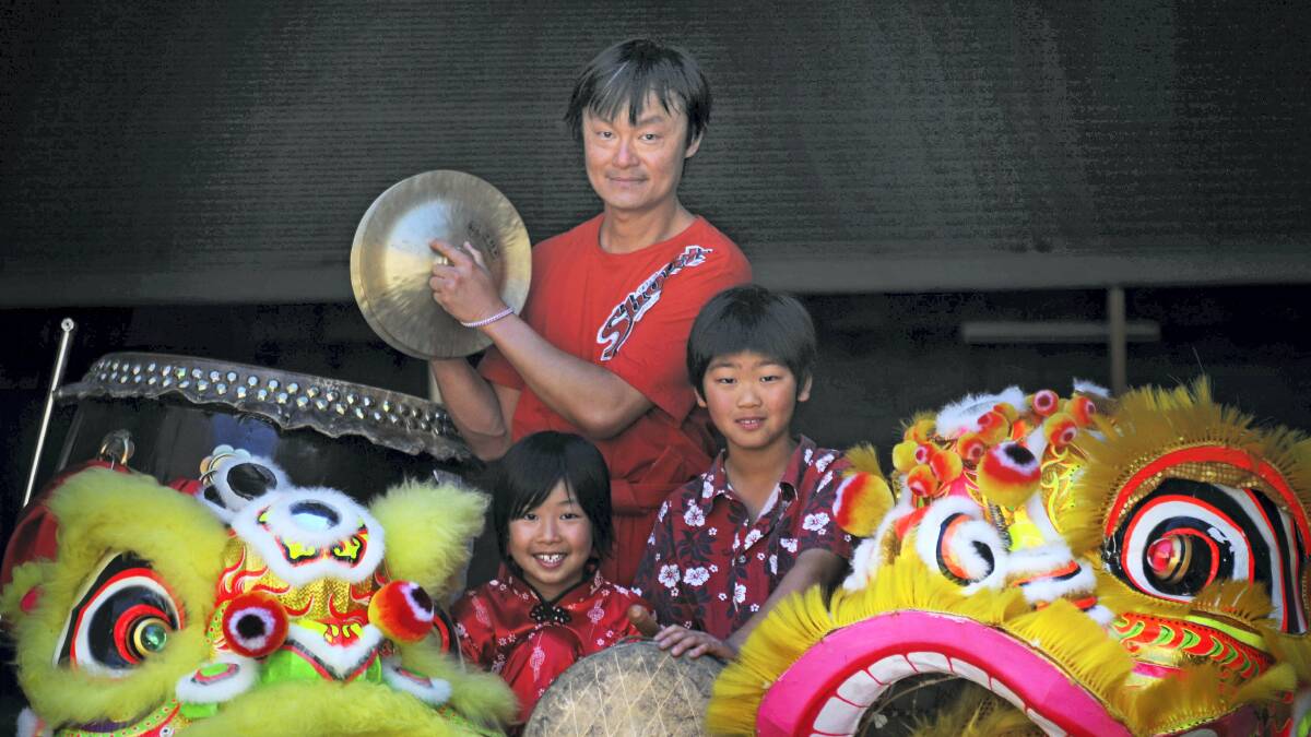 Lion dance troupe leader Wei-siong Liang with Ginger and Kyeong Morris, of Launceston, performing at yesterday's Chinese new year celebration at Launceston's Tsing Wah Asian Grocers. Picture: PHILLIP BIGGS