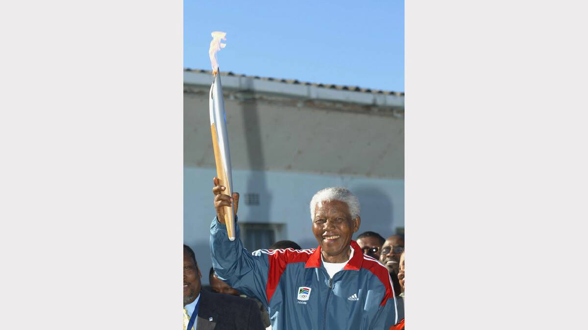  Nelson Mandela holds the Olympic Flame on Robben Island during Day 9 of the ATHENS 2004 Olympic Torch Relay June 12, 2004 in Cape Town, South Africa. 