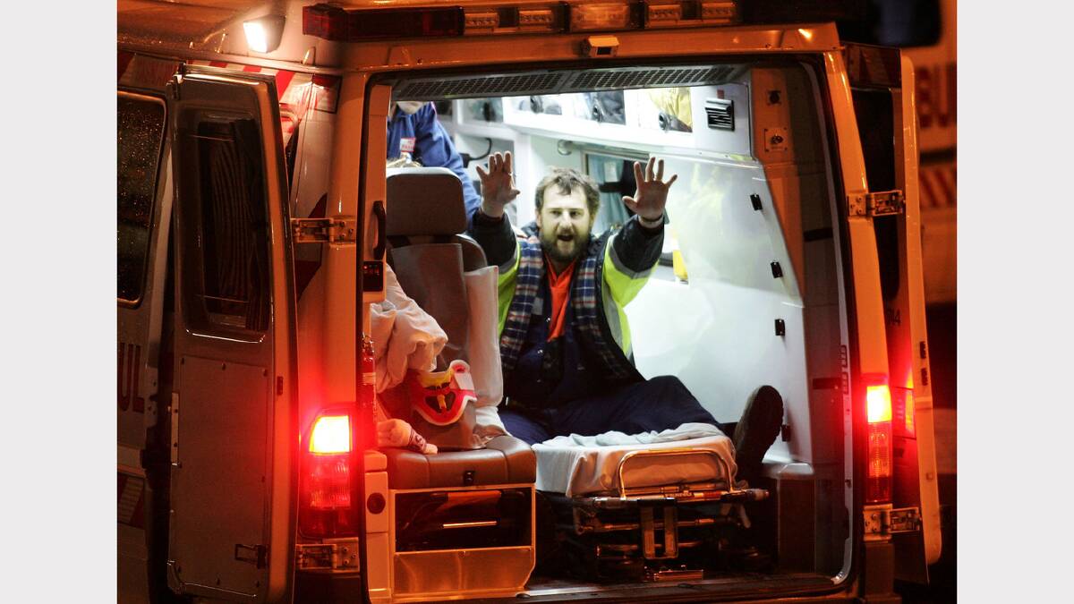 Todd Russell waves from the back of an ambulance after being rescued 