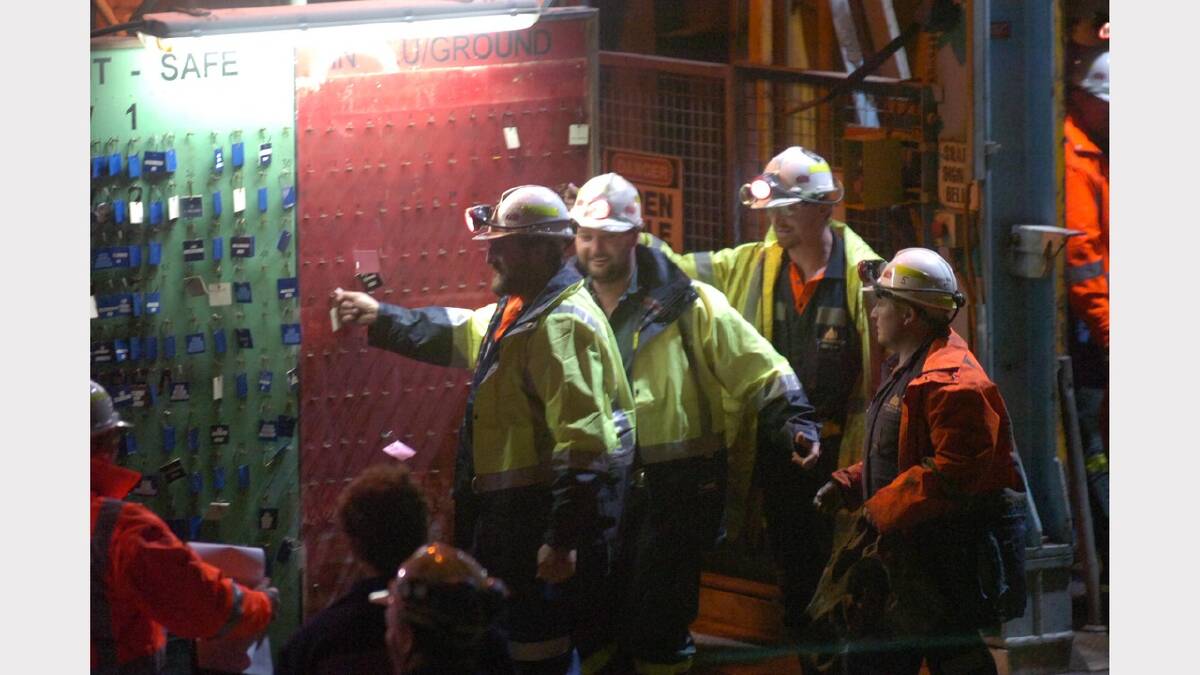 Todd Russell and Brant Webb proudly remove their name tags as soon as they emerged from the Beaconsfield mine.	