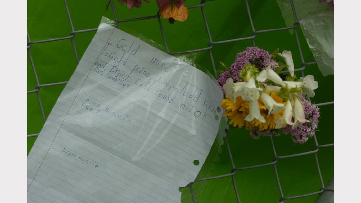 A bunch of flowers and a letter from Acacia 7 are fixed to the wire fence at the Beaconsfield Gold Mine.	
