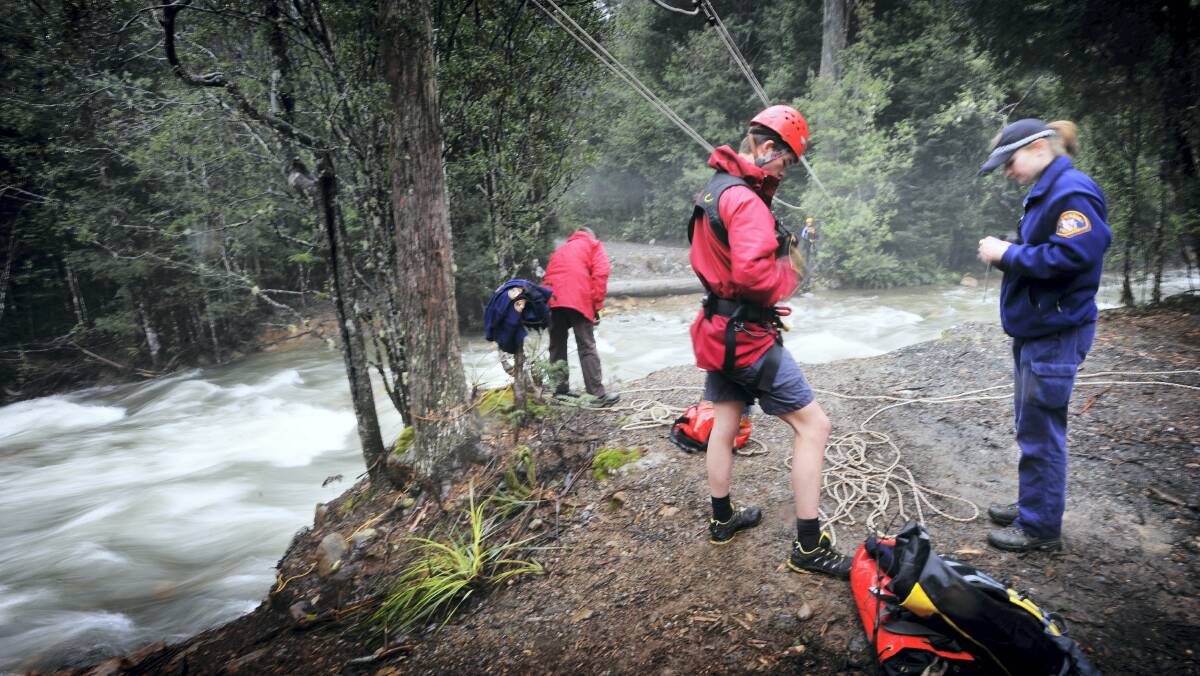 Senior Constable Leighton Riggall prepares to cross a flooded creek via a rope system to help rescue bushwalkers stranded near Meander Falls in July.