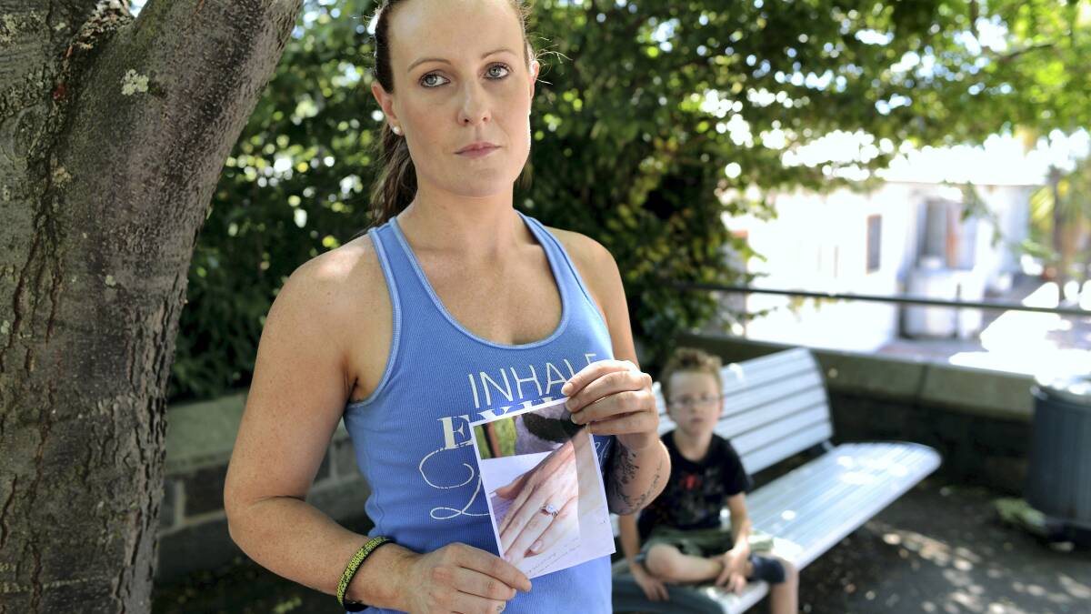 Newlywed Courtney Phillips at the bench near Hallams where her wedding rings were left, as her five-year-old son Tayte Romari looks on.  Picture: SCOTT GELSTON