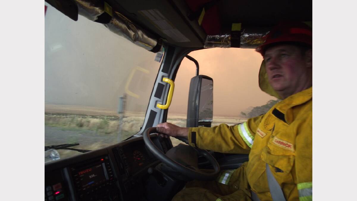 ''Carrick brigade chief Greg Cain as fire front approaches in front and along the township to his right''.